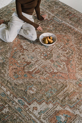 Close-up of the Zaman rug from the Oushak Collection, featuring a traditional pattern in olive, cream, terracotta and turquoise.