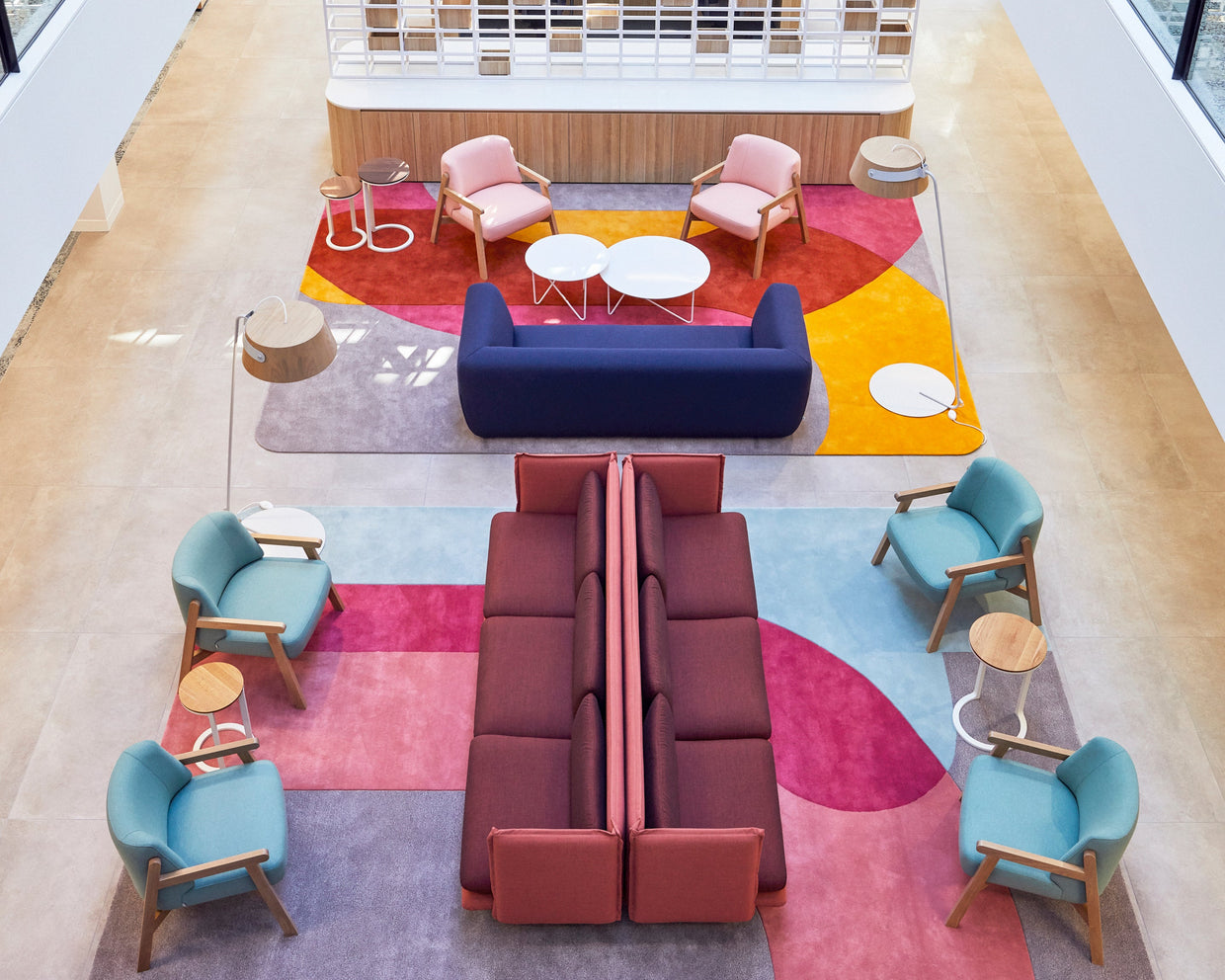 Round tables and chairs on a patterned red carpet in a busy hotel dining room, seen from above