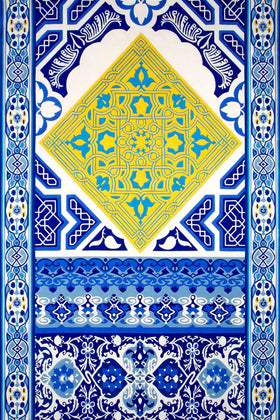 A square ceramic tile or decorative print featuring intricate Islamic geometric patterns in royal blue, navy, yellow, and white, with a large central diamond motif and ornate borders.