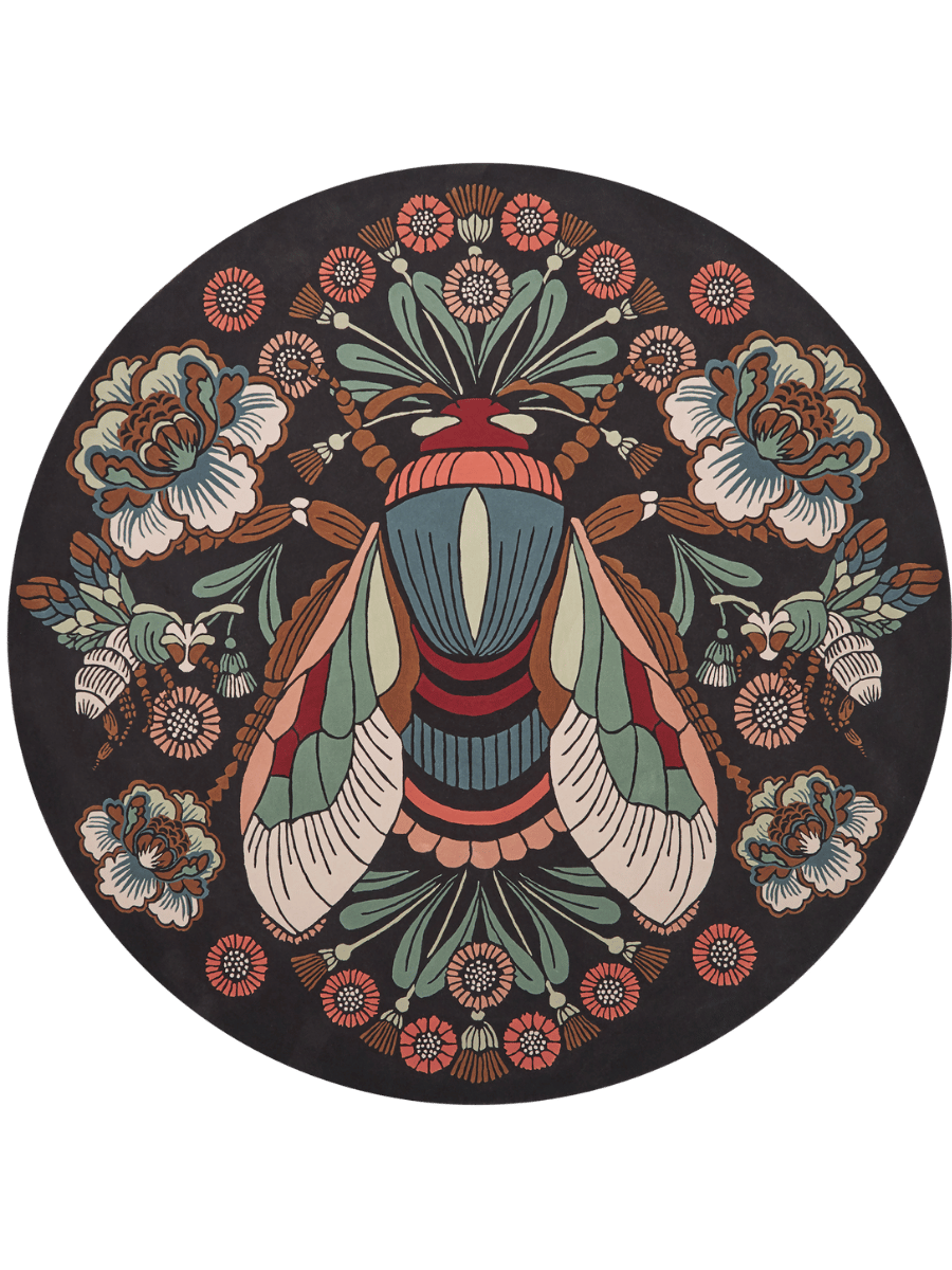 A circular black rug featuring a highly detailed, symmetrical vintage-style illustration of a large striped moth in the center, surrounded by floral motifs and smaller insects in muted teal, rust red, cream, and brown.