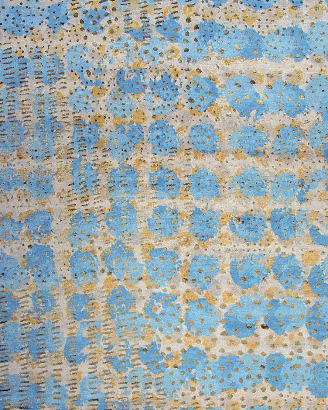 A close-up of a textured fabric or wallpaper pattern featuring light blue circular floral motifs, vertical dashed lines, and scattered gold glitter accents on a cream background.
