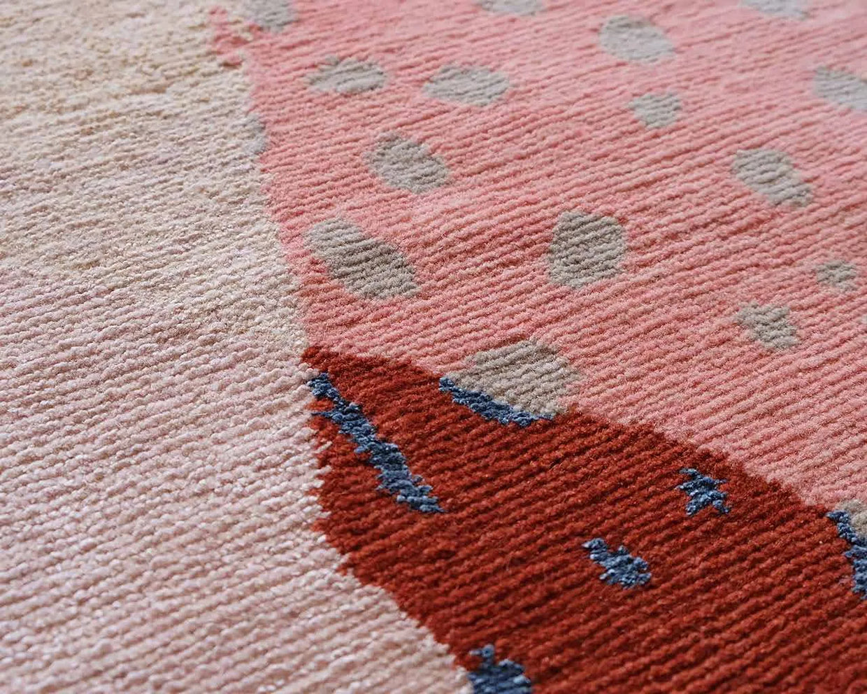 Handknotted pile in blush with red and blue