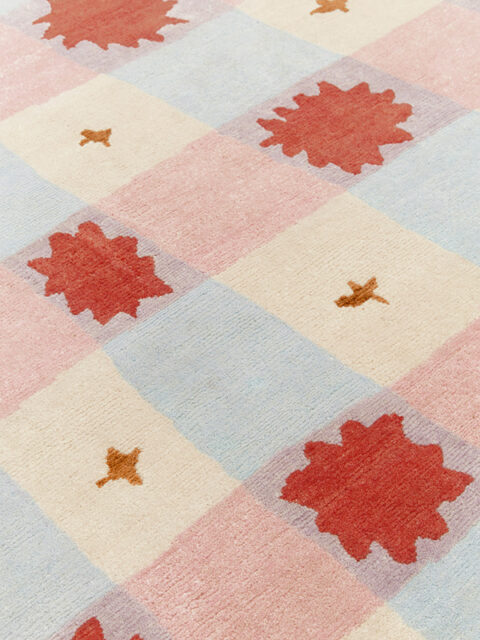 close up image of Quilt rug in pink, blue, gold and beige