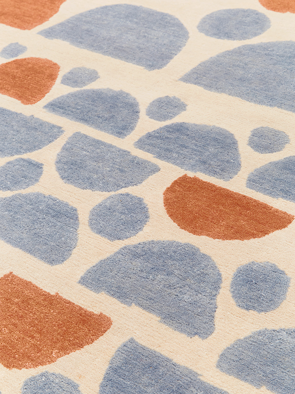 Close up image of Semi rug in blue, orange and beige