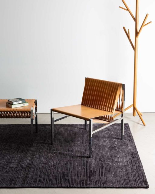 Living room view of textured Rhodium rug in charcoal colour